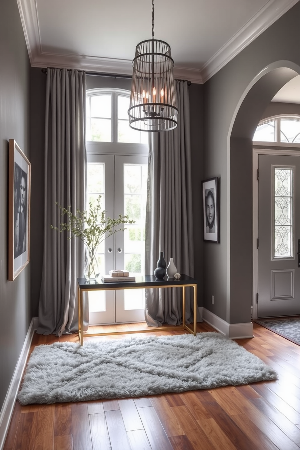 A stylish foyer features gray curtains gently framing a large window, allowing soft natural light to filter into the space. The walls are adorned with elegant artwork, and a sleek console table holds decorative items, creating an inviting atmosphere. The gray foyer design incorporates a plush area rug that adds warmth underfoot, contrasting beautifully with the polished hardwood floor. A statement pendant light hangs from the ceiling, illuminating the entryway and enhancing the overall sophistication of the space.