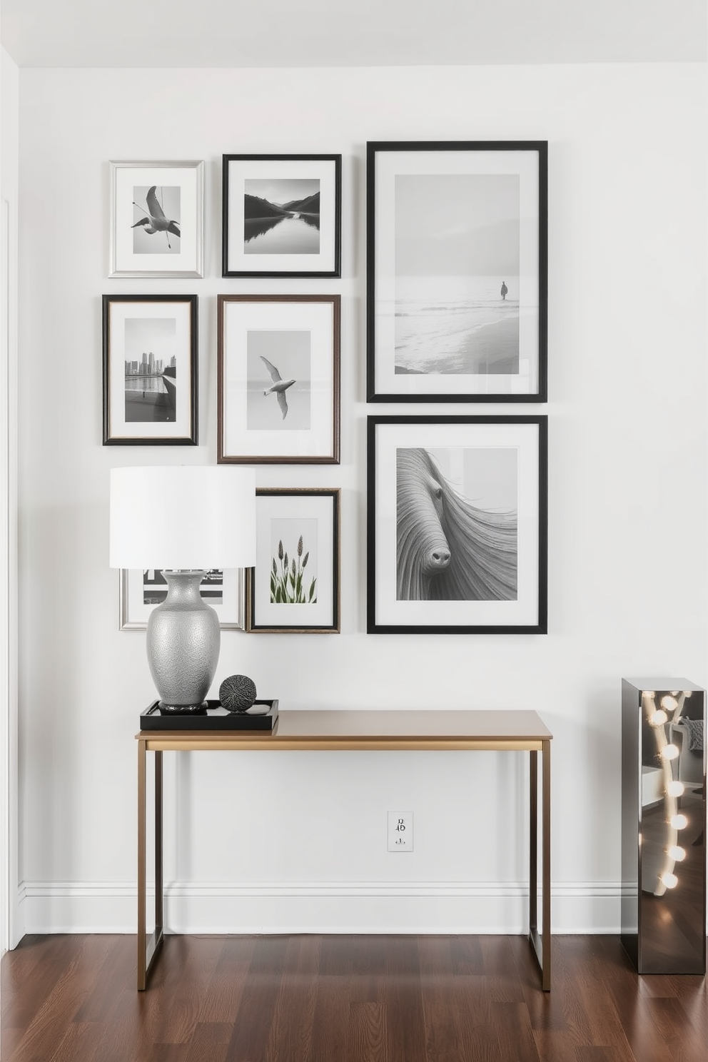 A stylish foyer featuring framed art pieces in various gray tones. The walls are adorned with a gallery of artwork, complemented by a sleek console table underneath.