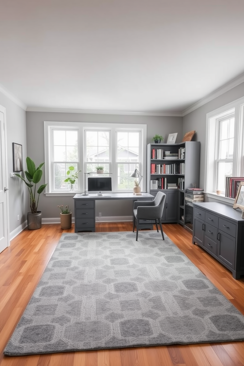 A gray area rug with geometric patterns is placed in the center of a spacious home office. The rug complements a sleek gray desk with a modern chair, creating a stylish and functional workspace. The walls are painted in a soft gray tone, enhancing the room's calm and professional atmosphere. Large windows allow natural light to flood the space, illuminating a few decorative plants and bookshelves filled with neatly organized books.