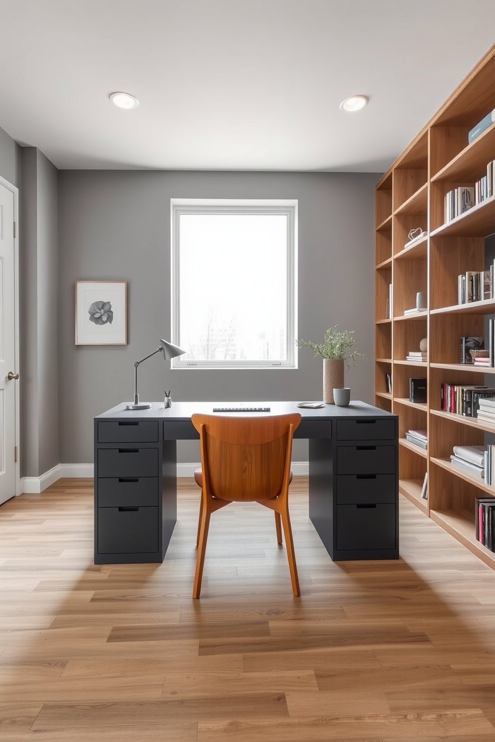 A contemporary gray desk is positioned in the center of a stylish home office. The desk is complemented by a warm wooden chair, creating a balanced and inviting workspace. The walls are painted in a soft gray tone, while a large window allows natural light to flood the room. A sleek bookshelf made of light wood lines one wall, filled with neatly organized books and decorative items.