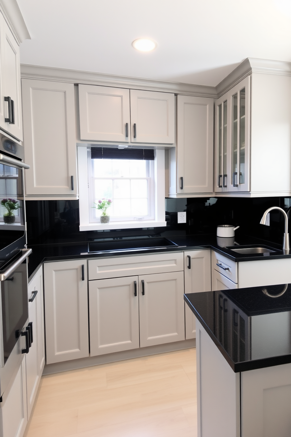 Light gray cabinetry with sleek dark countertops creates a modern and inviting atmosphere in the kitchen. The combination of these colors enhances the overall aesthetic, providing a stylish contrast that is both functional and visually appealing.