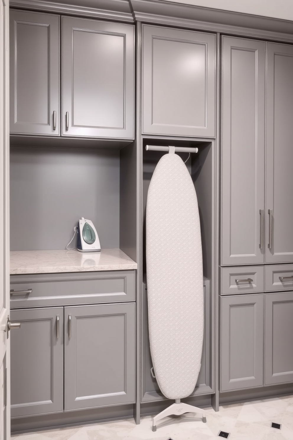 A sleek gray laundry room features a built-in ironing board seamlessly integrated into the cabinetry. The walls are adorned with matching gray cabinetry, providing ample storage and a clean, modern aesthetic.