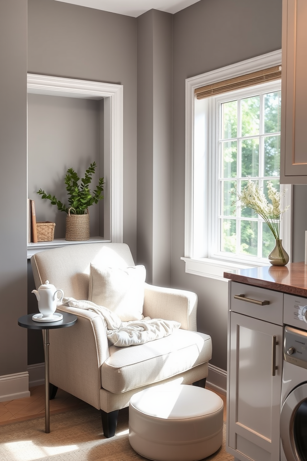 Cozy reading nook in laundry corner. A comfortable armchair upholstered in soft fabric is positioned beside a large window, with a small side table holding a steaming cup of tea and a stack of books. Gray laundry room design ideas. The walls are painted in a soft gray hue, complemented by sleek white cabinetry and a stylish countertop, creating a modern yet inviting atmosphere.