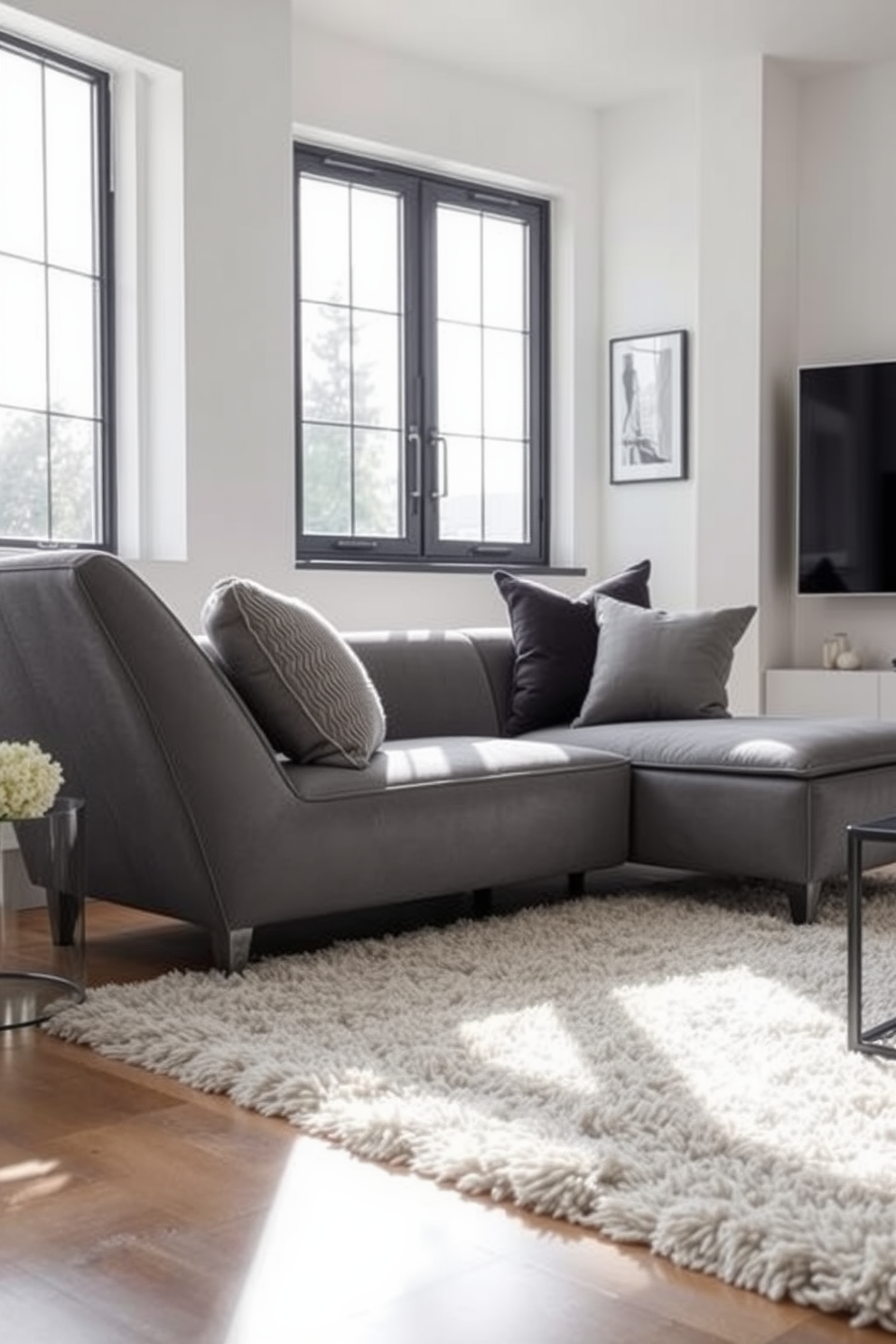 A stylish gray chaise lounge is placed elegantly in the corner of a contemporary living room. The walls are painted in a soft white hue, and the floor is adorned with a plush area rug that complements the chaise. Natural light streams in through large windows, highlighting the modern decor and sleek furniture arrangements. Accent cushions in varying textures and shades of gray add depth and comfort to the lounge area.