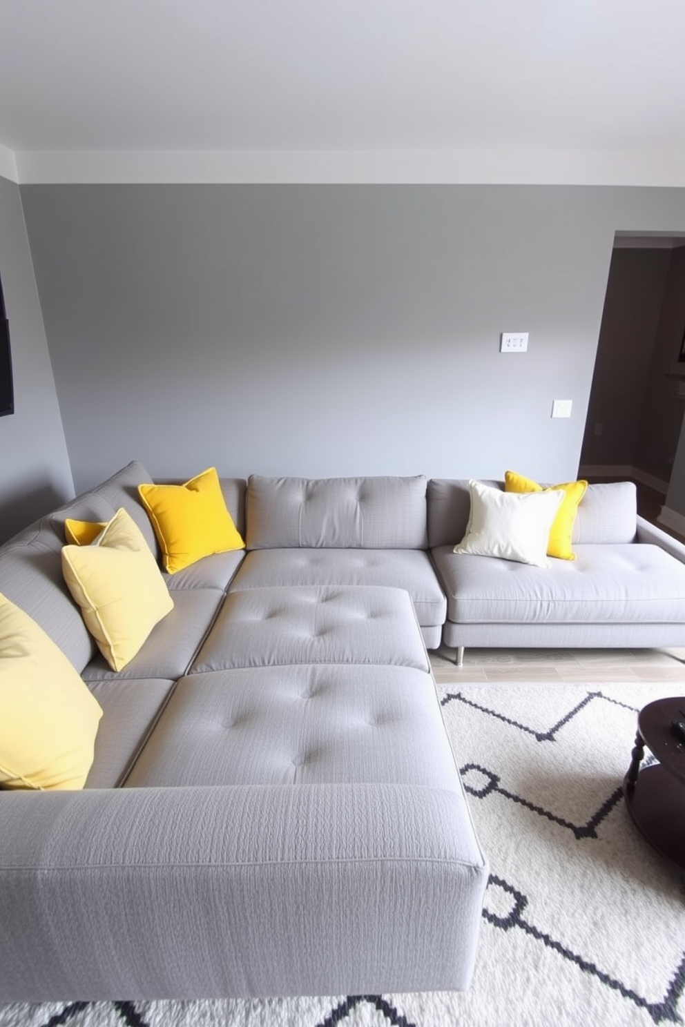 A sophisticated gray living room featuring a plush navy sectional sofa adorned with elegant throw pillows. The walls are painted in a soft gray hue, complemented by dark wood accents and a sleek coffee table in the center. Large windows allow natural light to flood the space, highlighting a stylish area rug that ties the color scheme together. A contemporary art piece hangs above the fireplace, adding a touch of personality to the refined atmosphere.