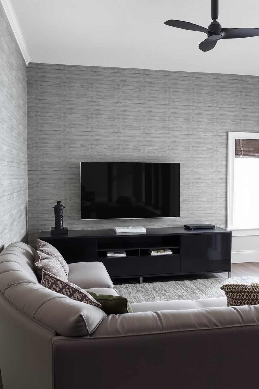 Elegant gray wallpaper with subtle patterns creates a sophisticated backdrop for the man cave. A plush sectional sofa in a complementary shade is positioned in front of a sleek media console, perfect for movie nights.