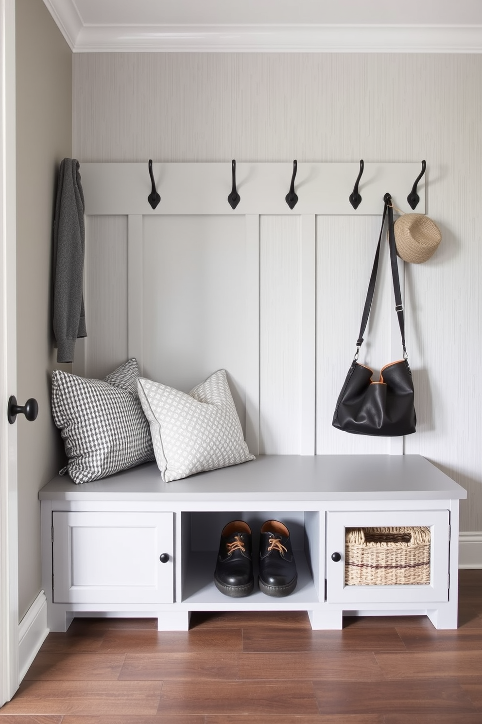 Cozy gray bench with storage underneath. The mudroom features a light gray color palette with shiplap walls and a durable tile floor.