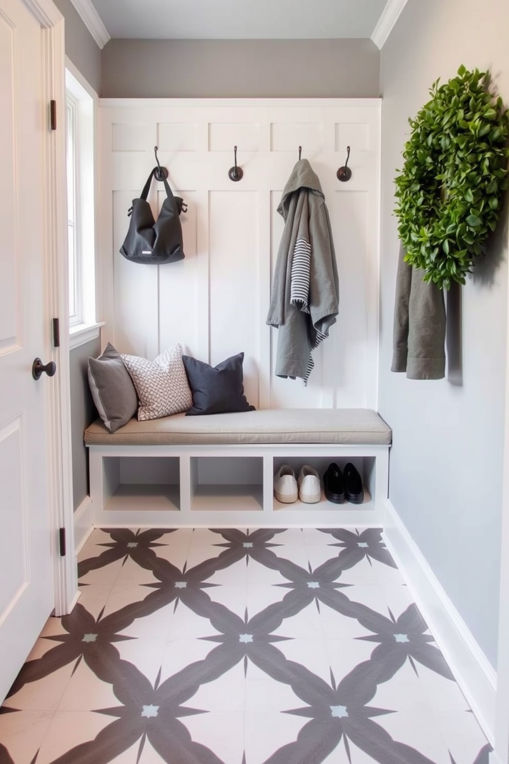 A stylish mudroom featuring gray and white patterned floor tiles that create a striking visual contrast. The space includes a built-in bench with plush cushions and hooks above for hanging coats and bags.