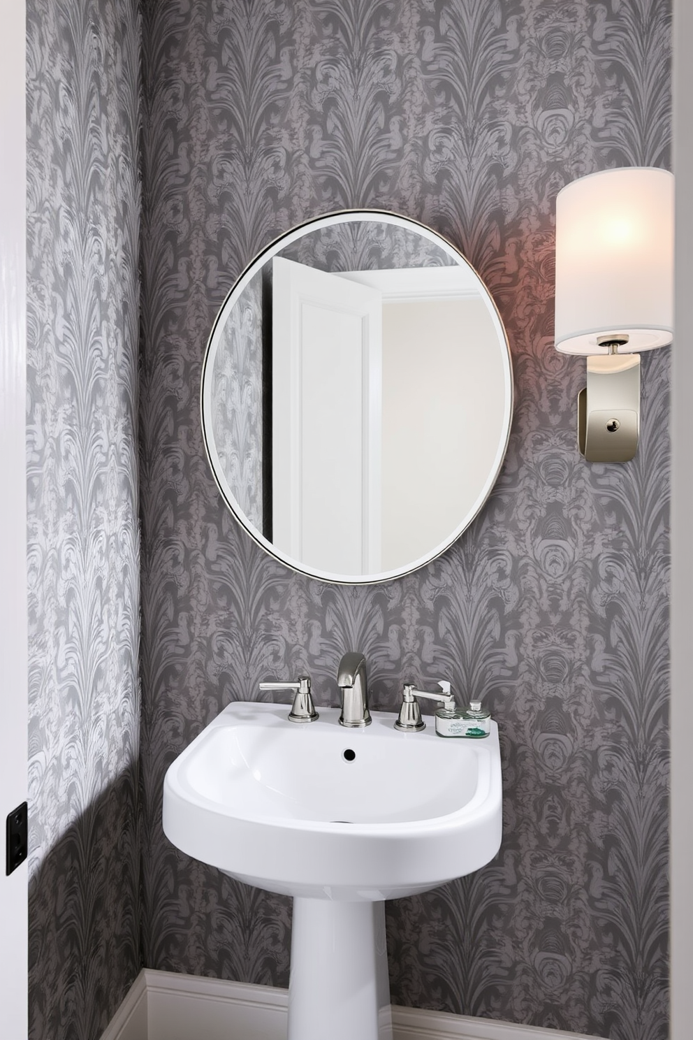 A stylish powder room featuring gray patterned wallpaper with an elegant design that adds depth and sophistication to the space. The room includes a sleek white pedestal sink and a modern round mirror that complements the wallpaper beautifully.