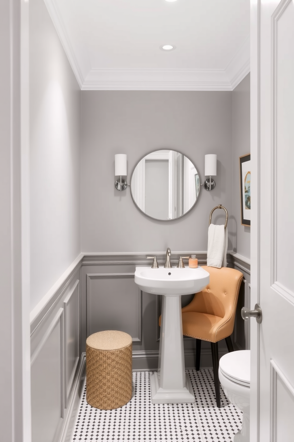 A stylish powder room featuring gray wainscoting that adds depth and elegance to the space. The upper walls are painted in a crisp white, creating a bright and airy atmosphere. The room includes a sleek pedestal sink with a modern faucet and a round mirror above it. A small accent chair in a complementary color is placed in one corner, adding a touch of comfort and style.