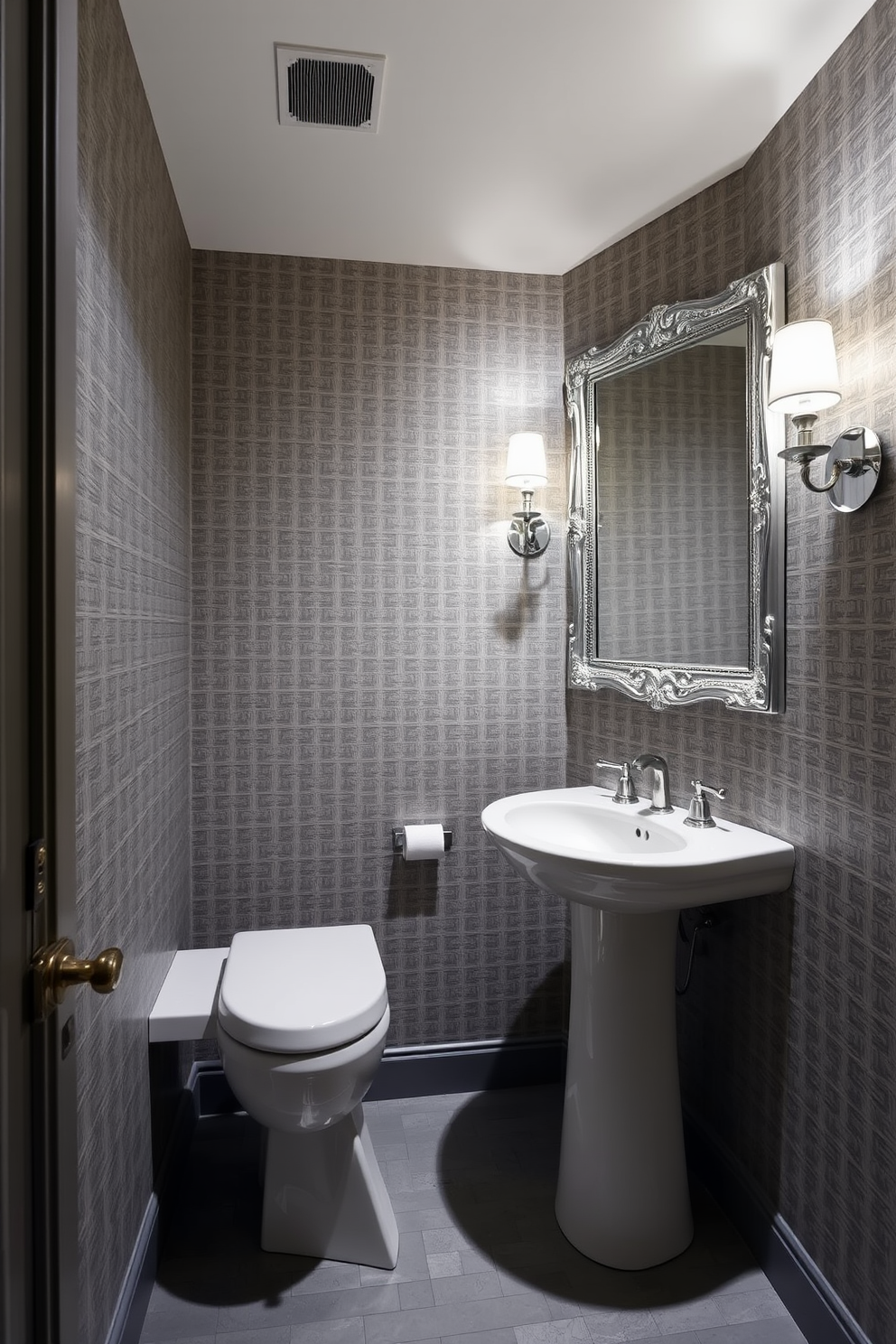 A sophisticated powder room featuring a gray and silver color scheme. The walls are adorned with a textured gray wallpaper, and the floor is covered in sleek silver tiles. A modern pedestal sink with a polished chrome faucet sits against one wall. Above the sink, an ornate silver-framed mirror reflects the soft ambient lighting from elegant sconces on either side.