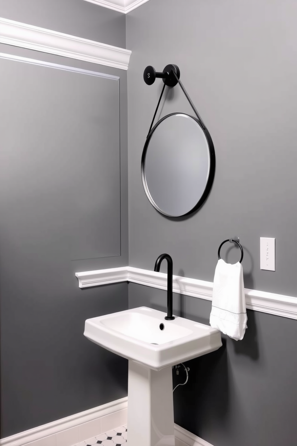 A chic powder room featuring bold gray paint on the walls, creating a striking backdrop. The contrasting white trim adds a touch of elegance, enhancing the overall sophistication of the space. A sleek pedestal sink is positioned against the wall, complemented by a modern wall-mounted faucet. A round mirror with a thin black frame hangs above the sink, reflecting the stylish ambiance of the room.