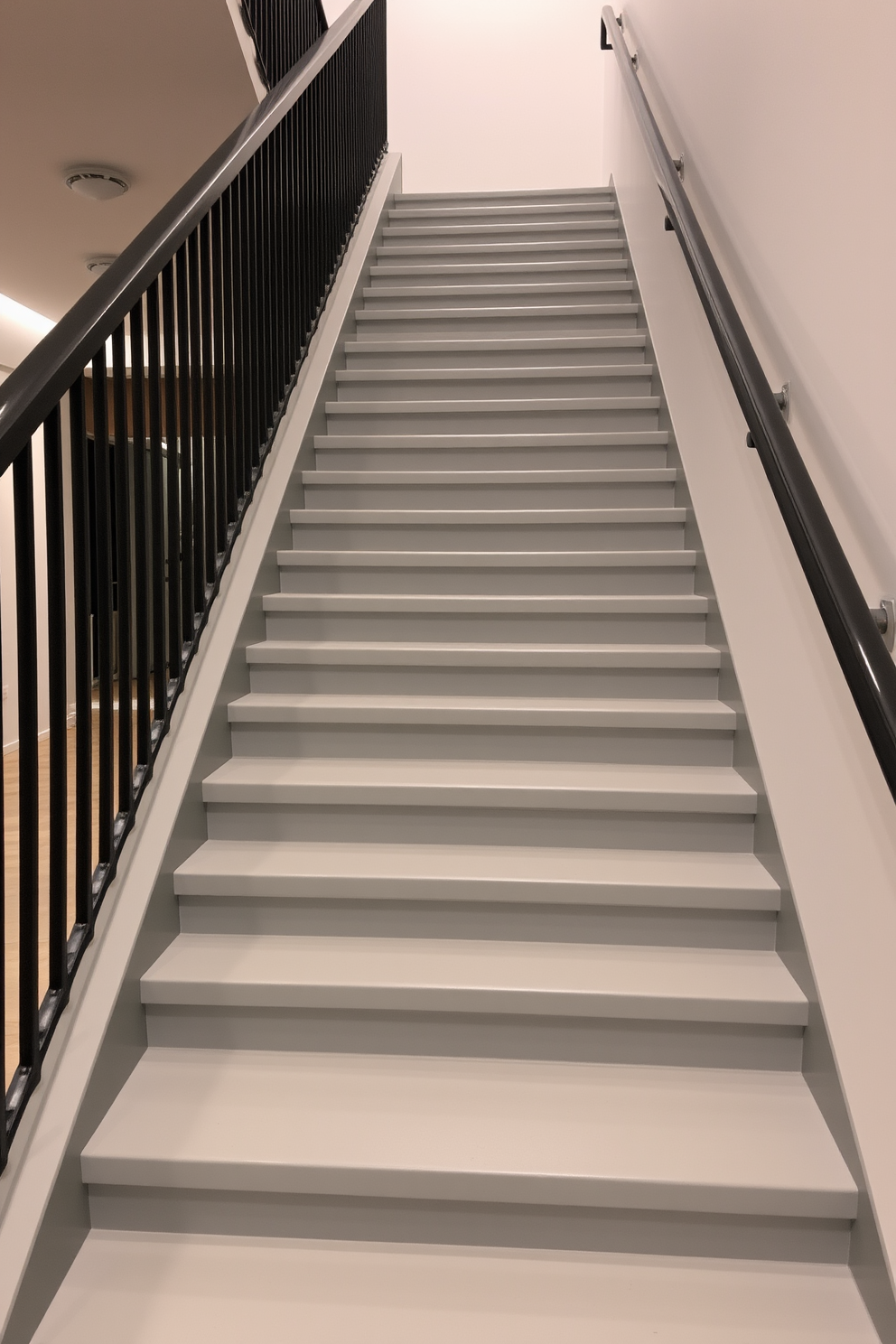 A stunning gray staircase ascends gracefully with a contrasting black railing that adds a touch of elegance. The staircase features sleek lines and a modern aesthetic, complemented by soft ambient lighting that highlights its architectural beauty.