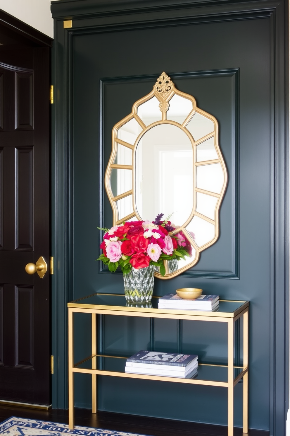 A dark green front door with elegant brass hardware welcomes guests into a stylish foyer. The space features a statement console table adorned with a decorative mirror and a vibrant arrangement of fresh flowers.