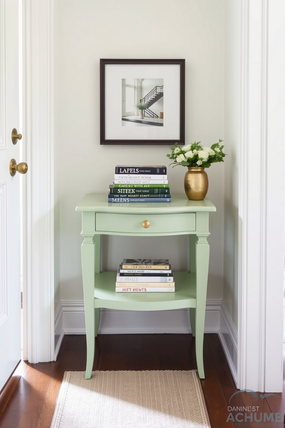 A pastel green side table stands elegantly in the corner of a bright foyer. It is adorned with a stack of carefully arranged books, adding a touch of sophistication to the space. The foyer features soft lighting that highlights the gentle hues of the pastel green. A stylish runner rug in neutral tones complements the table, creating an inviting atmosphere.