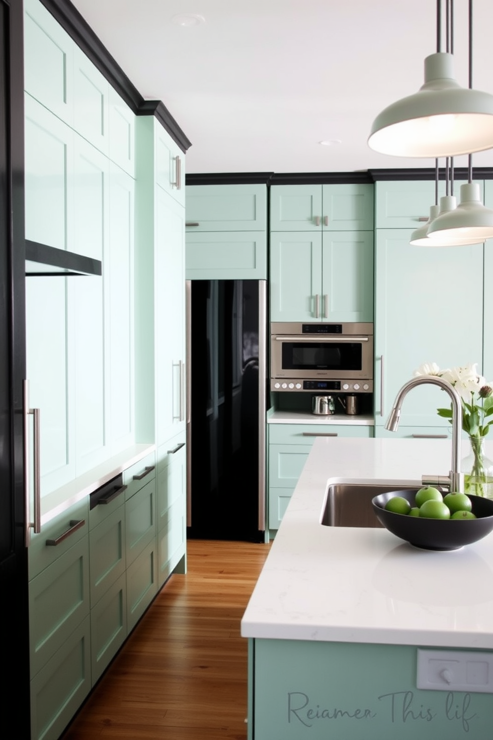 A stylish kitchen featuring seafoam green cabinets complemented by sleek black accents. The countertops are a polished white quartz, and modern pendant lights hang above the island, illuminating the space.