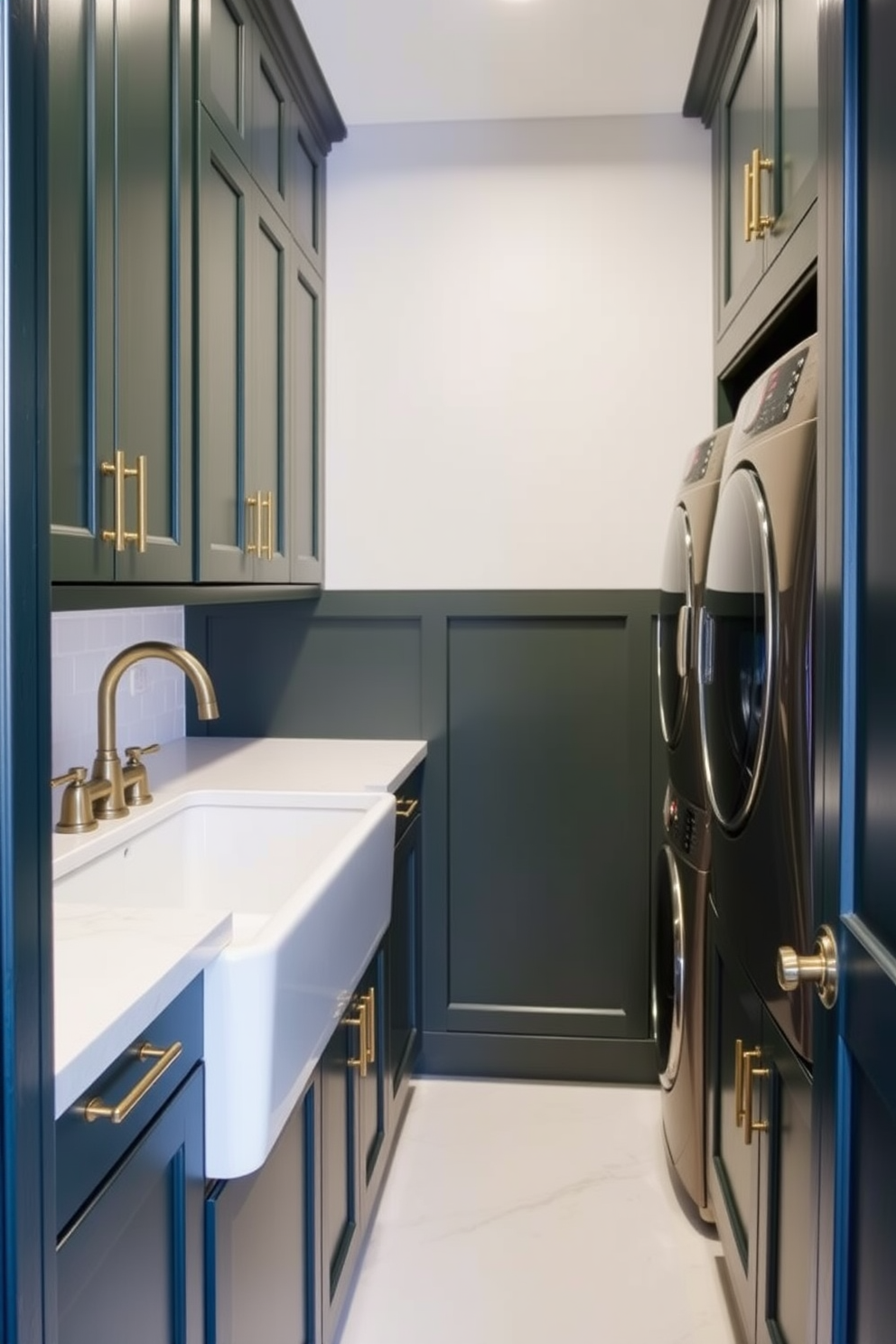 A stylish laundry room features hunter green cabinets with sleek brass fixtures that add a touch of elegance. The space is brightened by natural light streaming in through a large window, enhancing the rich color of the cabinets.