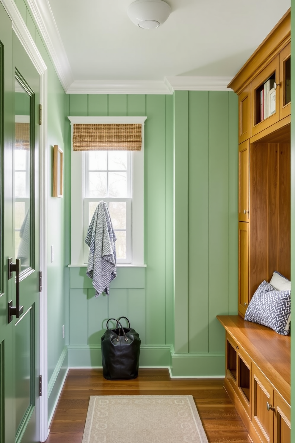 A mint green mudroom island features a spacious countertop with ample storage underneath. The walls are adorned with shiplap in a complementary shade, and a row of hooks provides a practical solution for hanging coats and bags.