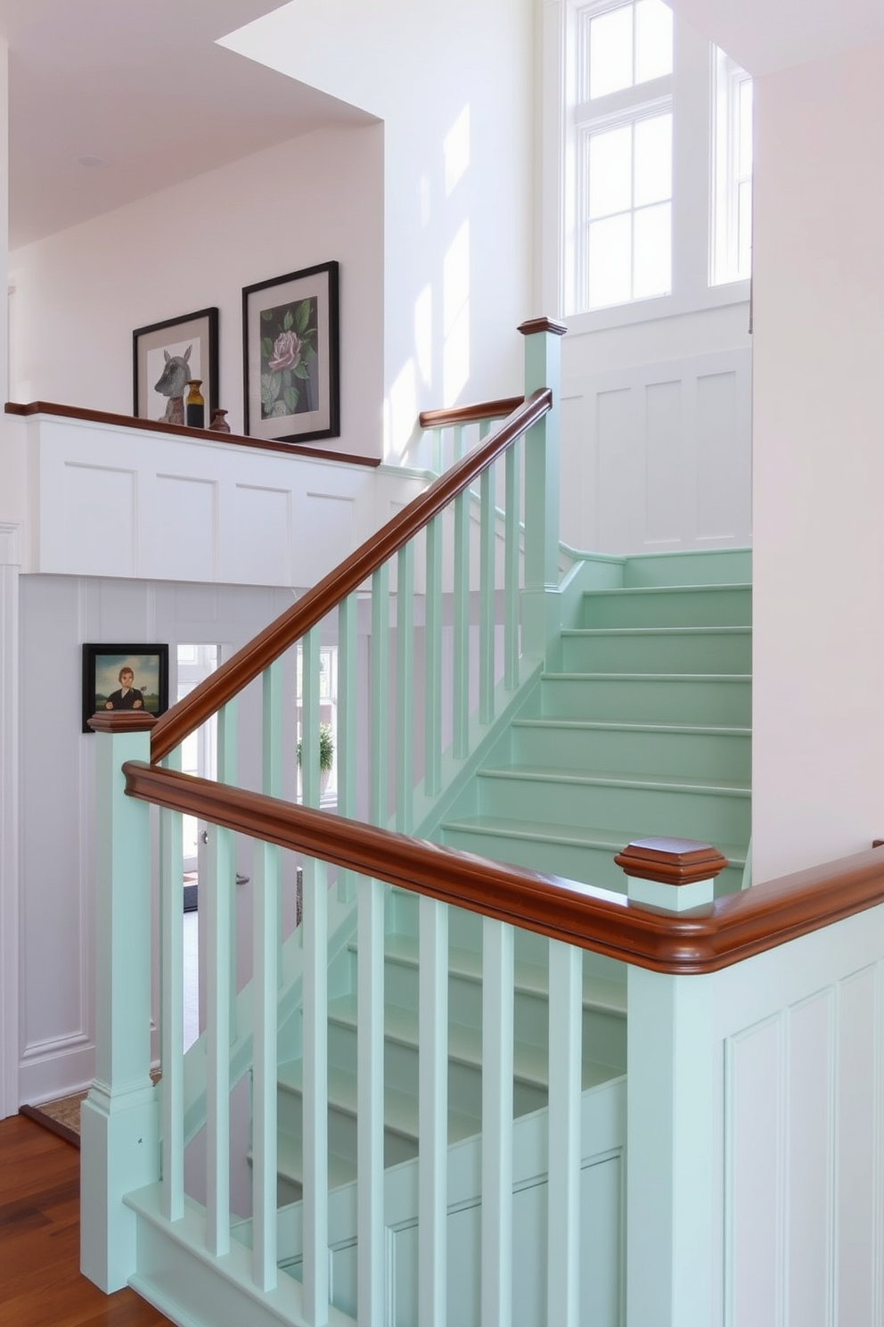 A mint green staircase with a sleek wooden railing gracefully ascends to the upper level of the home. The walls are adorned with subtle white wainscoting, creating a fresh and inviting atmosphere that complements the staircase's color. Natural light floods the space through large windows, illuminating the soft mint hue and highlighting the rich texture of the wooden railing. Decorative artwork hangs along the walls, adding personality and charm to the overall design.