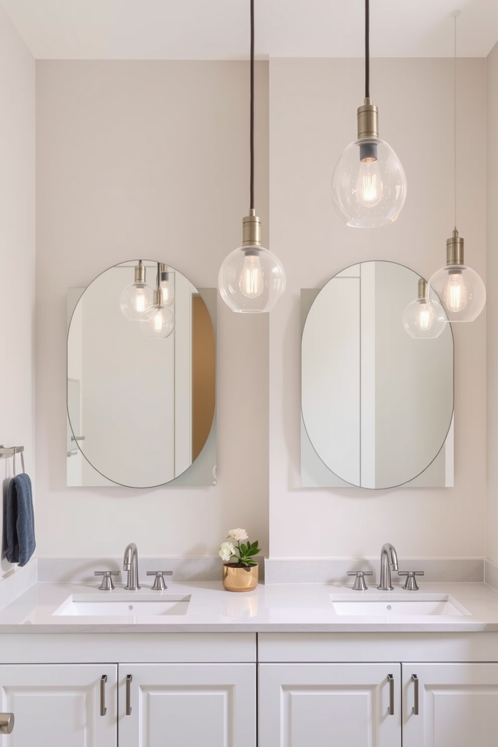 A stylish guest bathroom featuring elegant pendant lighting fixtures that hang gracefully above the sinks. The walls are adorned with soft neutral tones, complementing the sleek cabinetry and polished fixtures.