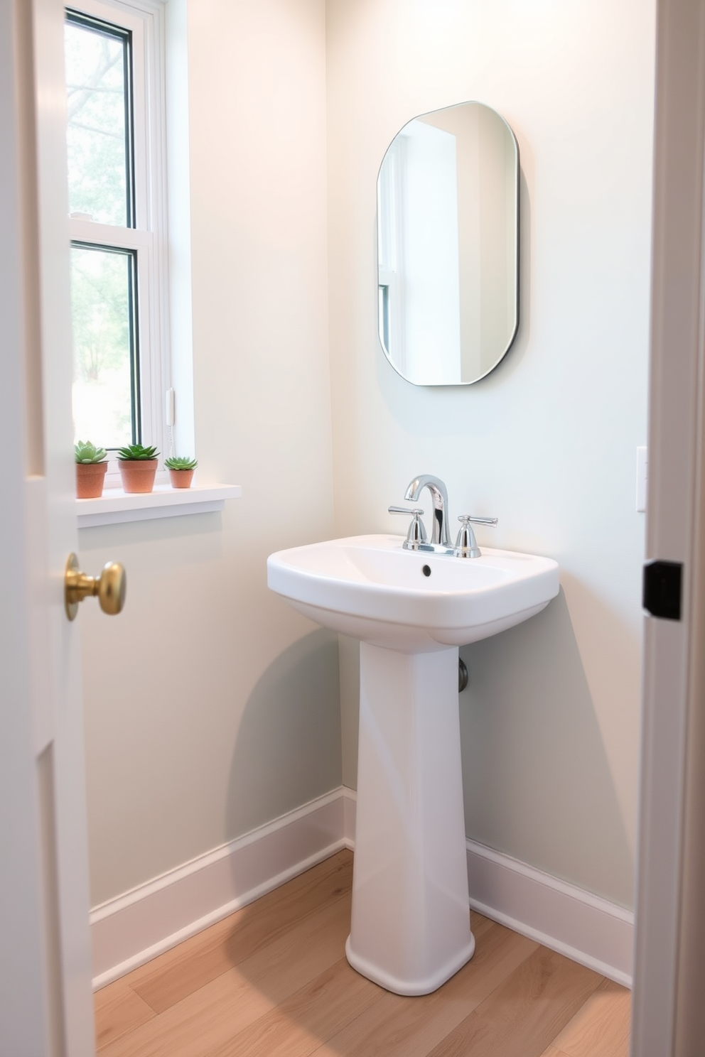 A stylish half bath featuring a sleek pedestal sink with a polished chrome faucet. The walls are adorned with a soft pastel color, and a series of small succulent plants are arranged on the windowsill for a fresh touch. The floor is covered in a light wood laminate, adding warmth to the space. A minimalist mirror hangs above the sink, reflecting the natural light and enhancing the airy feel of the powder room.