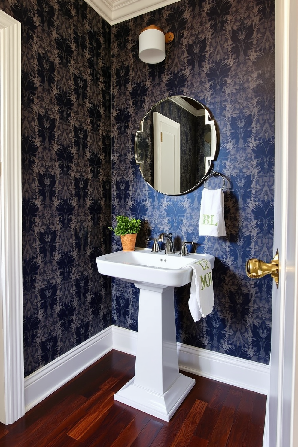 A stunning half bath featuring bold patterned wallpaper that creates a dramatic focal point. The space includes a sleek pedestal sink with a stylish faucet and a round mirror above it, enhancing the room's elegance. The flooring is a rich dark wood that contrasts beautifully with the vibrant wallpaper. A small potted plant adds a touch of greenery, while decorative hand towels are neatly arranged for a polished look.