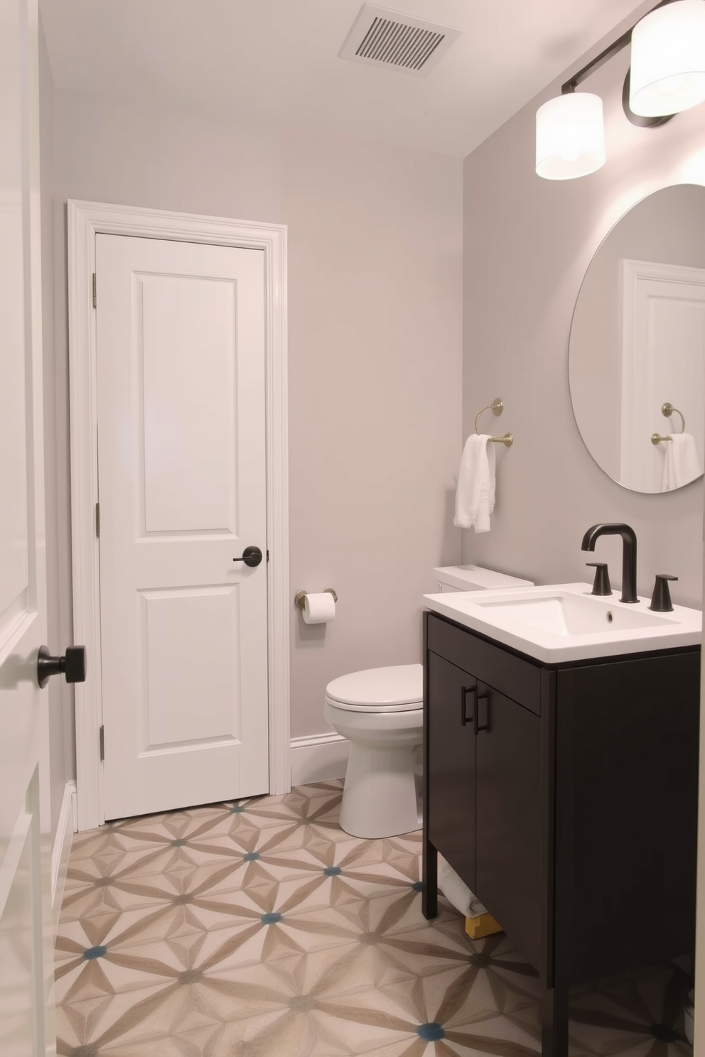 A compact vanity with sleek lines features a smooth white countertop and a single sink. Above the vanity, a round mirror with a minimalist frame reflects the soft lighting, enhancing the spacious feel of the half bath. The walls are painted in a soft gray, complemented by elegant wall sconces on either side of the mirror. A small potted plant sits on the vanity, adding a touch of greenery to the refined powder room design.