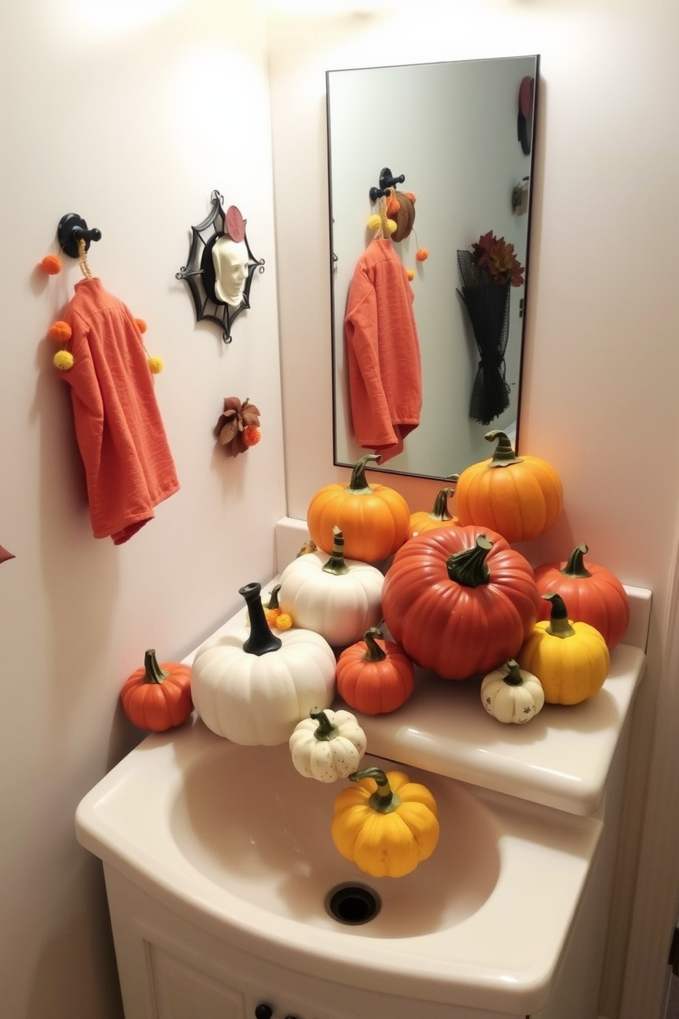 A whimsical Halloween bathroom setting featuring decorative pumpkins in various sizes arranged on a wooden shelf. The pumpkins are a mix of orange, white, and green hues, creating a festive atmosphere alongside autumn-themed towels and a spooky candle arrangement.