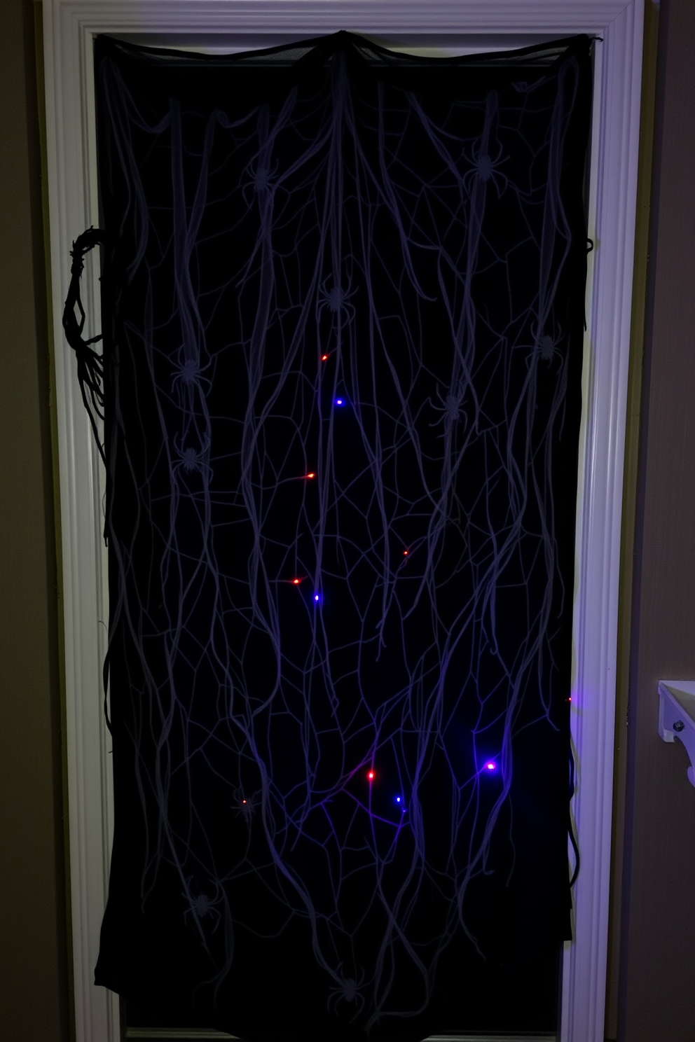 A giant spider web stretches across the doorway creating a spooky entrance. The web is adorned with small plastic spiders and eerie decorations to enhance the Halloween atmosphere.