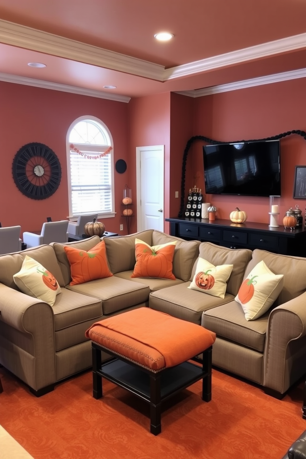 A cozy game room featuring a large sectional sofa adorned with pumpkin-themed throw pillows in various shades of orange and cream. The walls are painted in a warm, inviting hue, and festive Halloween decorations are strategically placed throughout the space to create a playful atmosphere.