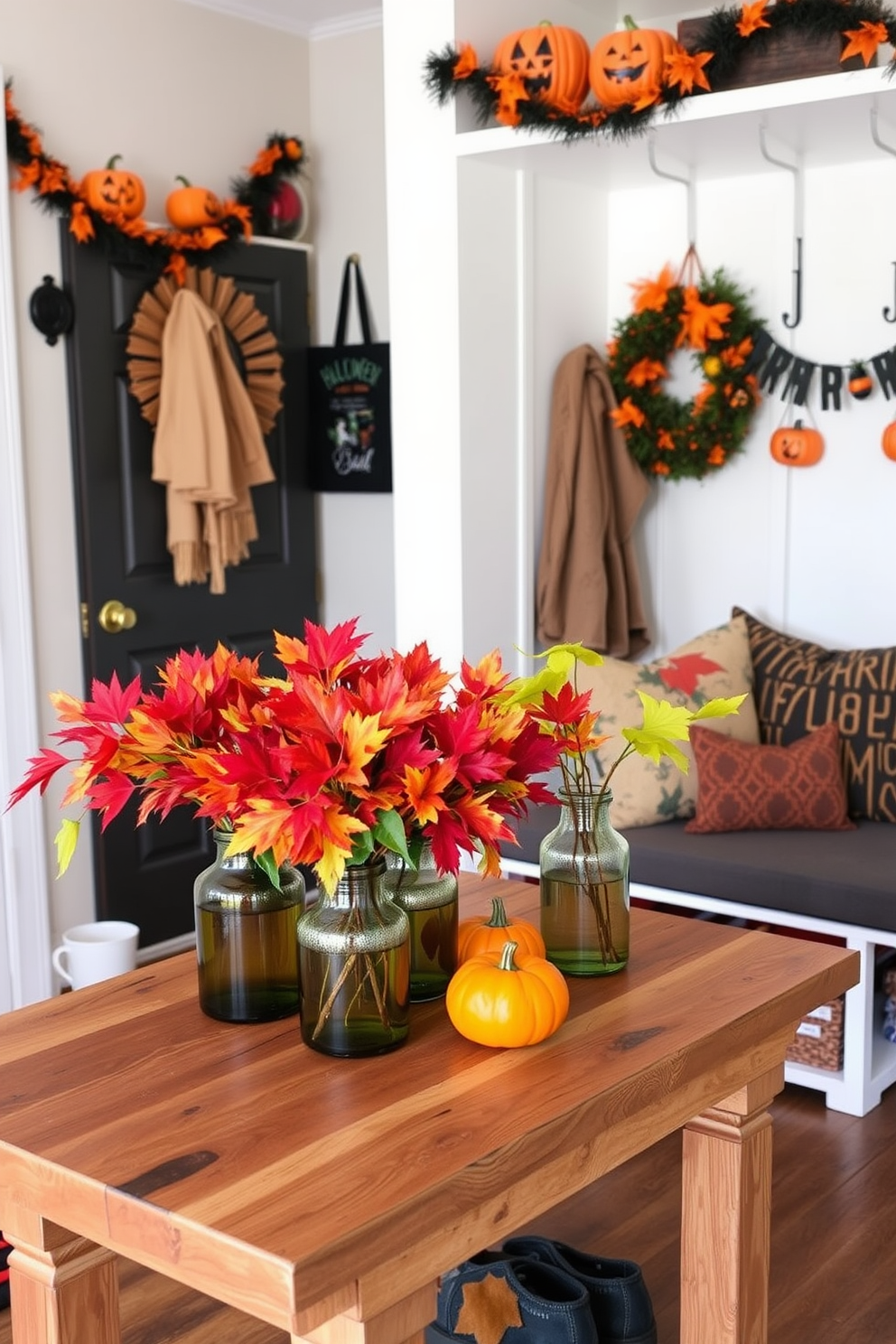 Colorful fall foliage in vases is arranged artistically on a rustic wooden table. The vibrant reds, oranges, and yellows of the leaves create a warm and inviting atmosphere in the space. Halloween decorations adorn the mudroom, featuring playful elements like miniature pumpkins and spooky garlands. A cozy bench with seasonal throw pillows provides a perfect spot to sit while putting on shoes.