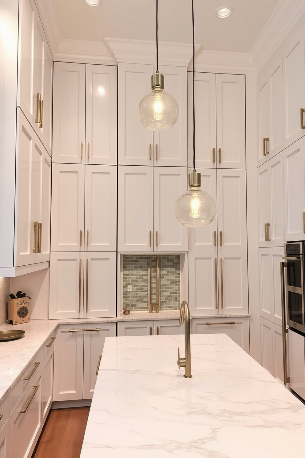 A high ceiling kitchen featuring tall cabinetry that provides ample storage space. The cabinetry is finished in a sleek white with gold hardware, creating a modern and elegant look. The kitchen island is large and functional, topped with a stunning quartz countertop. Pendant lights hang gracefully from the ceiling, illuminating the space with a warm glow.