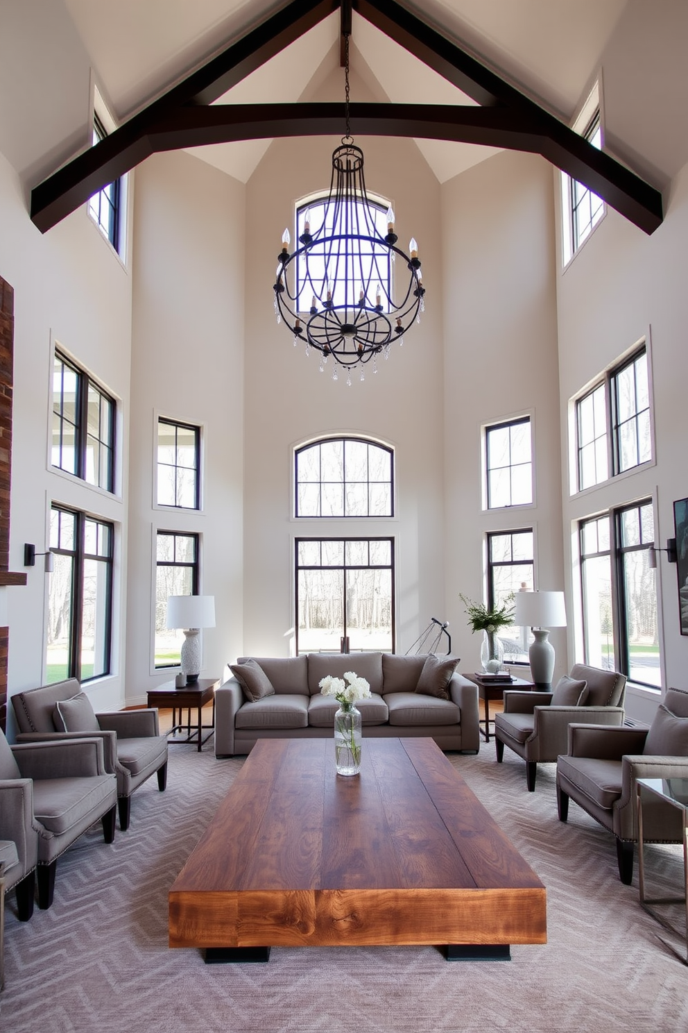 A spacious living room with high ceilings featuring large windows that allow natural light to flood the space. In the center, a large coffee table made of reclaimed wood is surrounded by a plush sectional sofa and elegant armchairs. The walls are painted in a soft neutral tone, creating a calming atmosphere. A striking chandelier hangs from the ceiling, adding a touch of sophistication to the overall design.