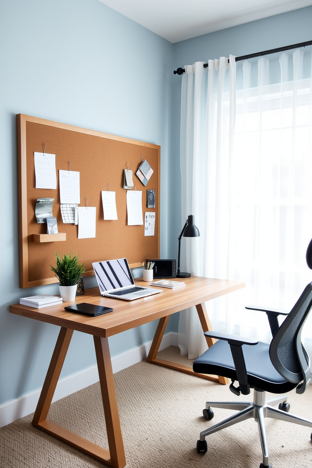 A stylish home office featuring a large wooden desk positioned against a wall with a bulletin board for organization. The desk is adorned with a sleek laptop, a potted plant, and stationery, while the walls are painted in a calming light blue tone. To the right of the desk, a comfortable ergonomic chair complements the workspace. Natural light floods the room through a large window dressed with sheer curtains, creating an inviting atmosphere for productivity.