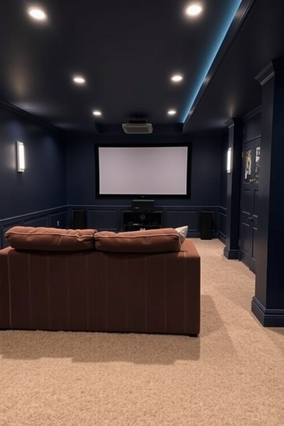 A cozy home theater basement featuring a plush cuddle couch positioned in front of a large screen. The walls are painted in a deep navy blue, with soft ambient lighting and a plush area rug to enhance the inviting atmosphere.