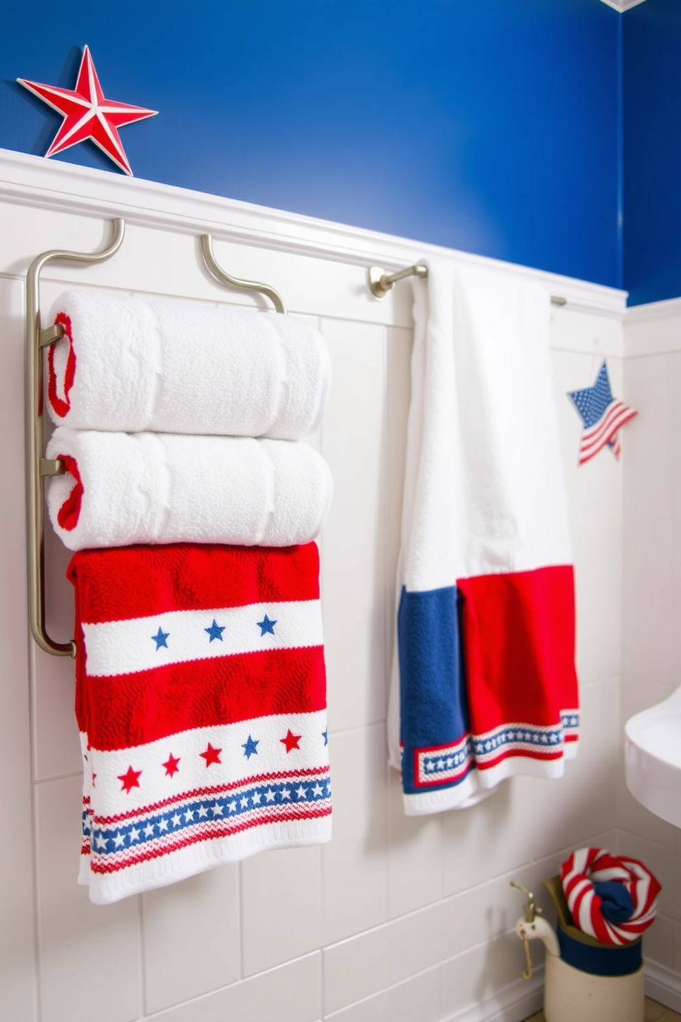 A vibrant bathroom setting featuring a star spangled shower curtain that celebrates Independence Day. The walls are painted in a crisp white, and the floor is adorned with navy blue tiles, creating a patriotic atmosphere. A wooden vanity with a red finish complements the decor, topped with a white countertop. Decorative elements include a small American flag placed on the vanity and a matching red and white striped towel hanging nearby.