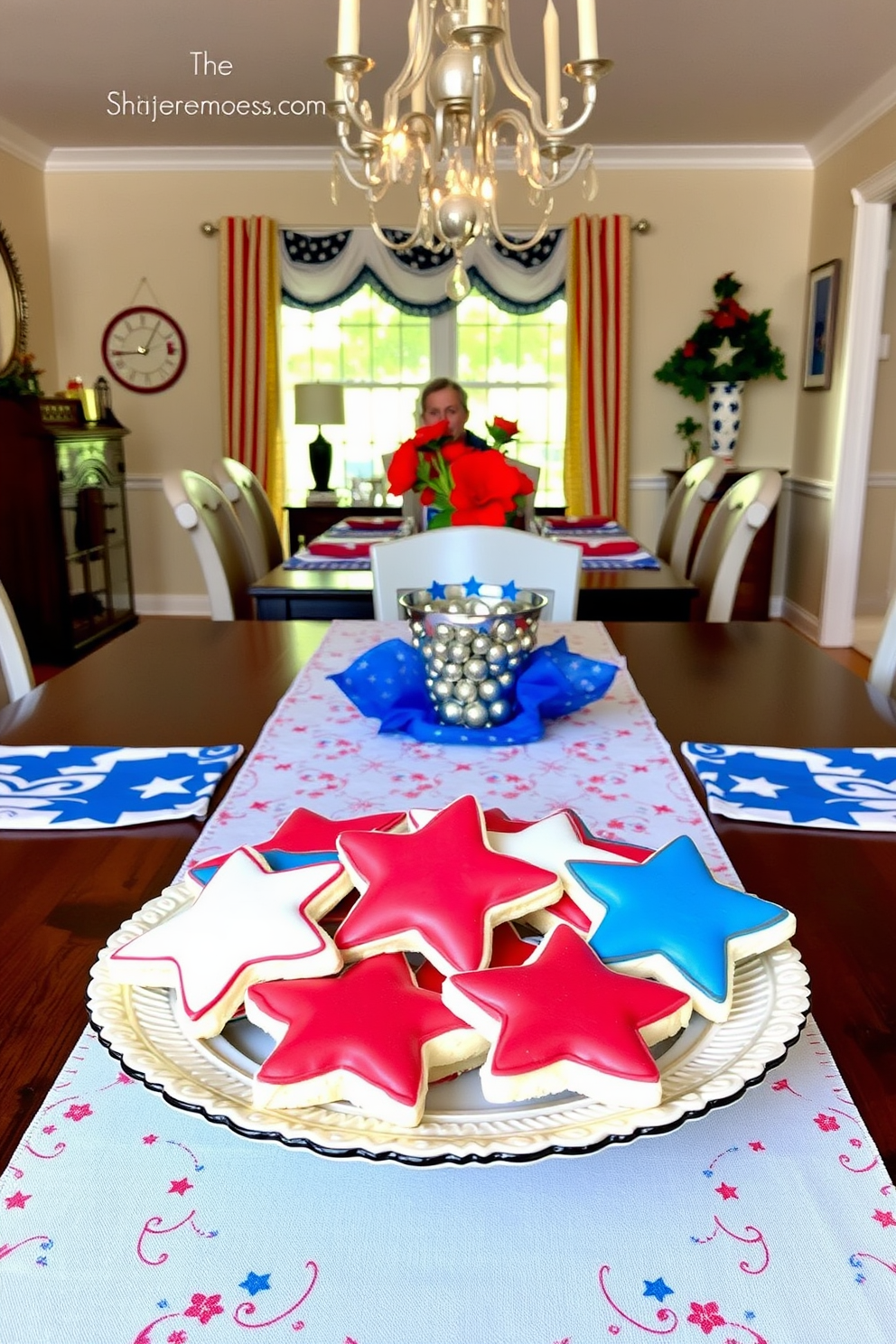 Star shaped cookies arranged on a decorative platter serve as delightful table decor for a festive Independence Day celebration. The dining room features a patriotic color scheme with red white and blue accents including table linens and centerpieces.