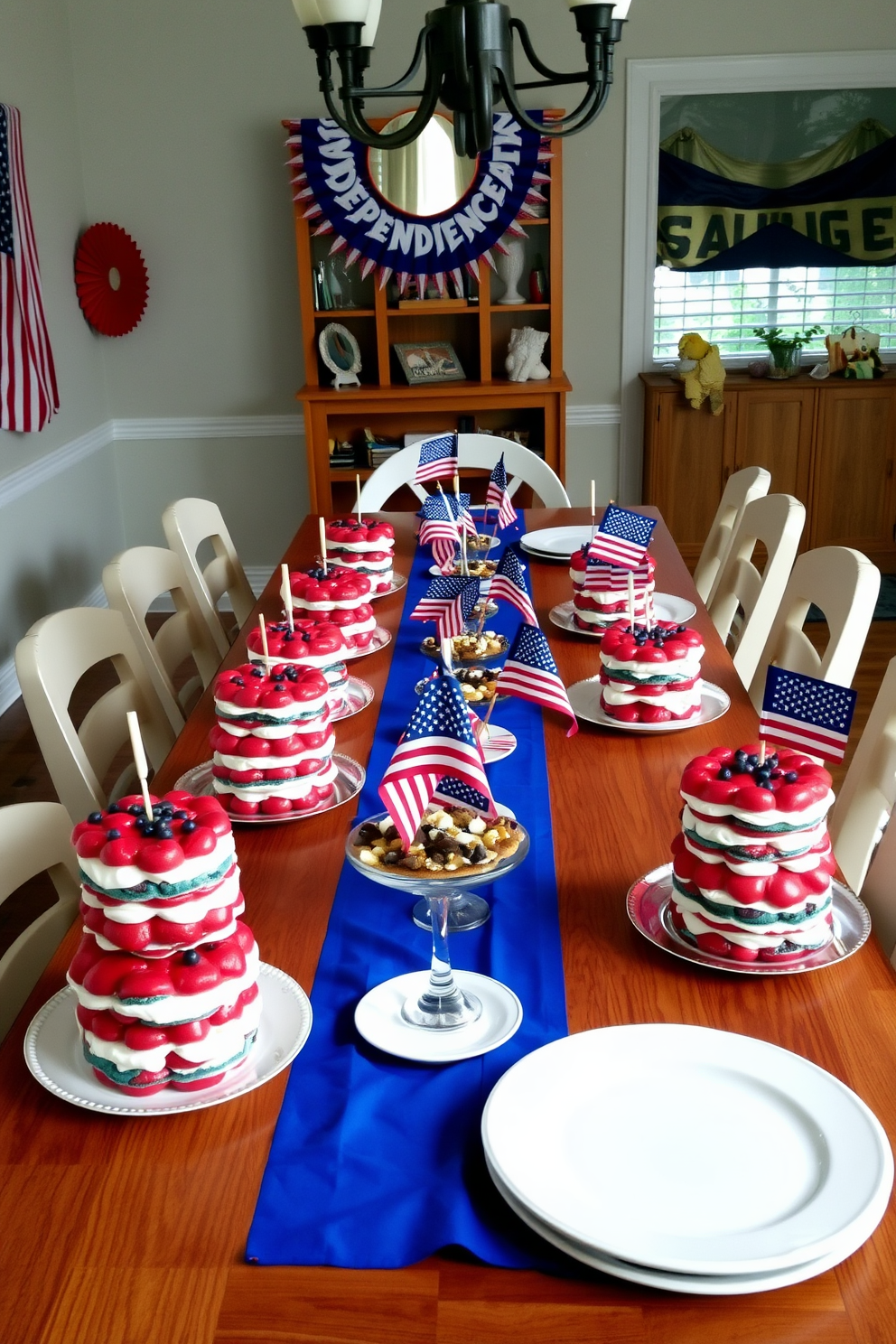 A festive dining room decorated for Independence Day features a long wooden table set with layered red white and blue desserts. The table is adorned with a blue tablecloth and white plates, while small American flags are placed in between the desserts for a patriotic touch.