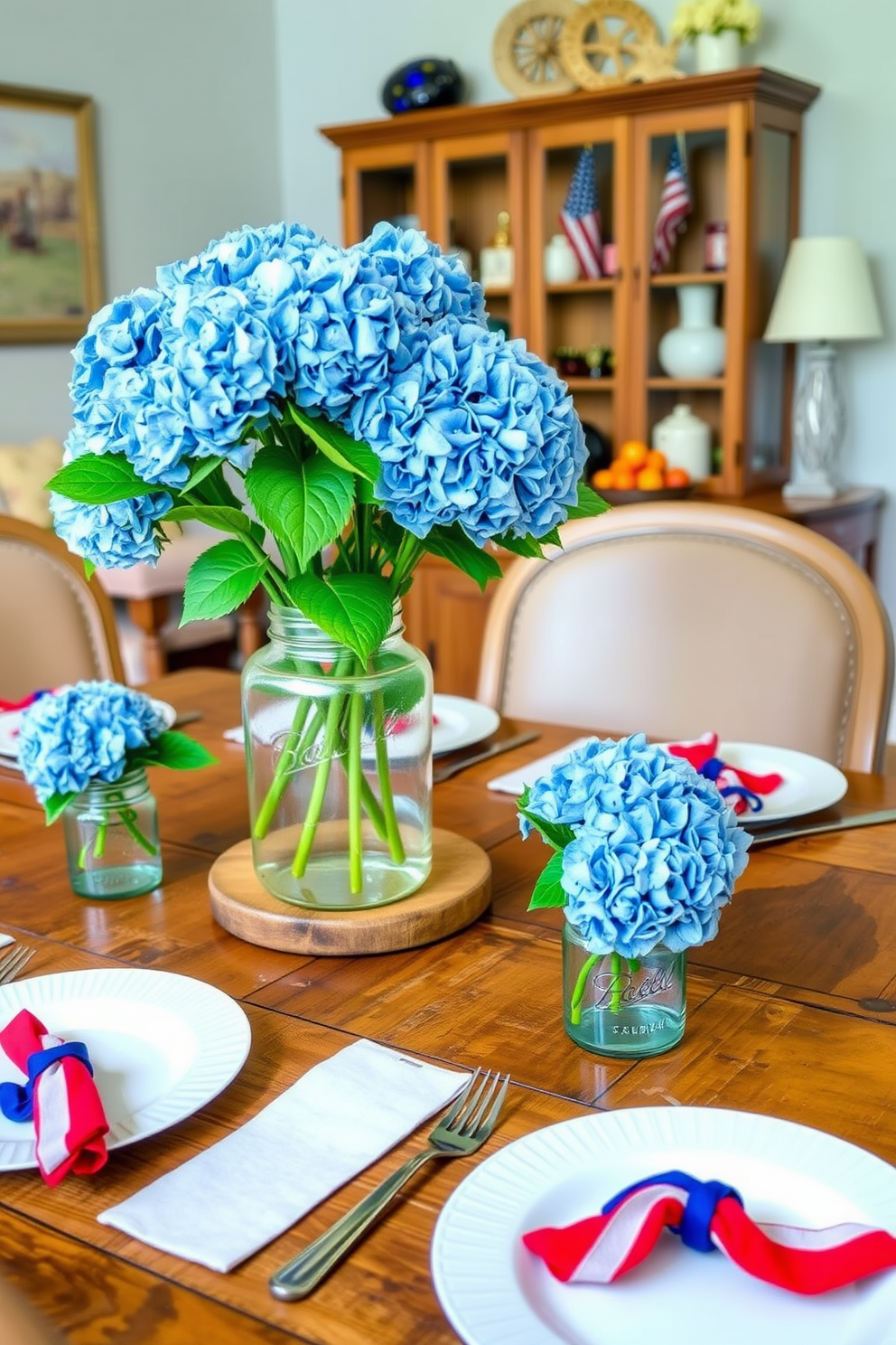 A charming dining room setting adorned with blue hydrangeas in mason jars placed on a rustic wooden table. The table is set with white dinnerware and red, white, and blue napkins, creating a festive atmosphere for Independence Day celebrations.