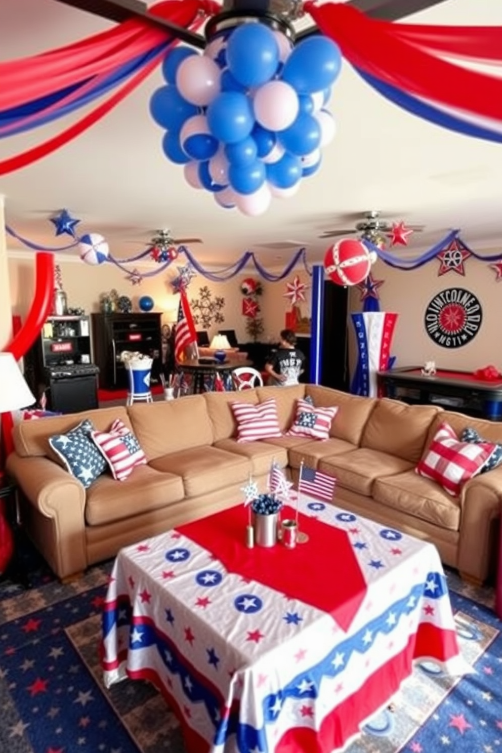 A vibrant game room decorated for Independence Day features red white and blue inflatable decorations scattered throughout the space. The room includes a large sectional sofa adorned with patriotic throw pillows and a coffee table draped in a festive tablecloth.