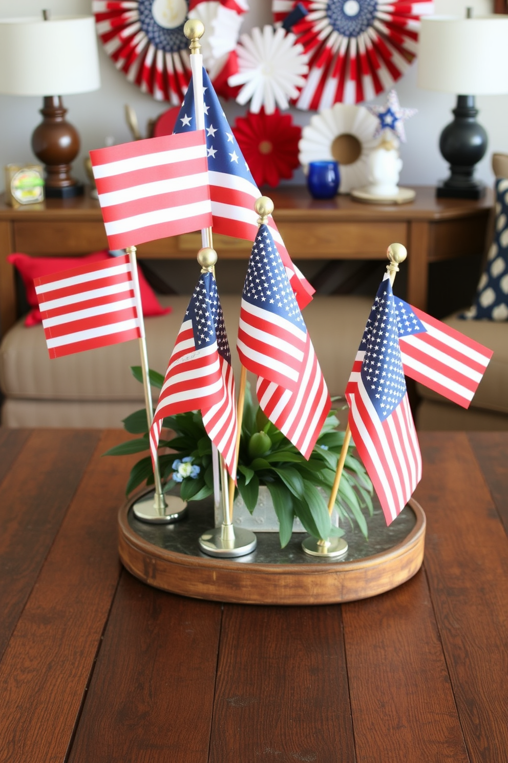 Tabletop flags in various sizes are artfully arranged on a rustic wooden coffee table. The flags are complemented by a backdrop of red white and blue decor creating a festive atmosphere for Independence Day celebrations.