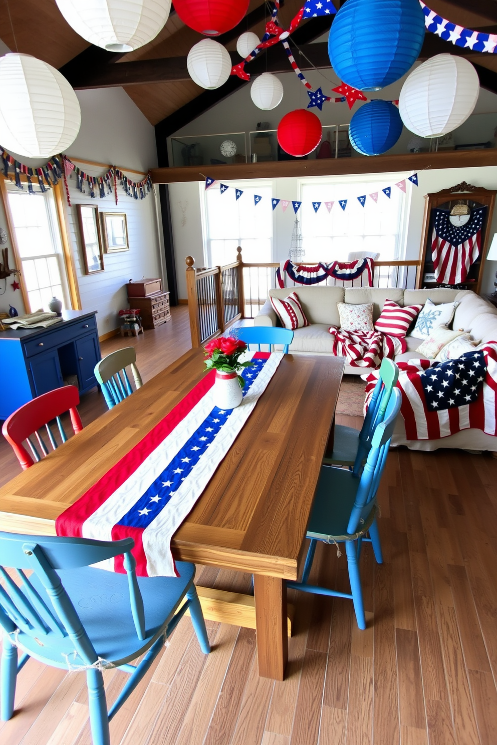 A festive table runner adorned with red white and blue stripes and stars stretches across a rustic wooden dining table. Surrounding the table are mismatched chairs painted in vibrant colors evoking a sense of celebration and unity. In the loft space patriotic decorations hang from the ceiling including paper lanterns and bunting. A cozy seating area is created with an oversized sectional couch draped in a flag-patterned throw blanket and adorned with themed cushions.