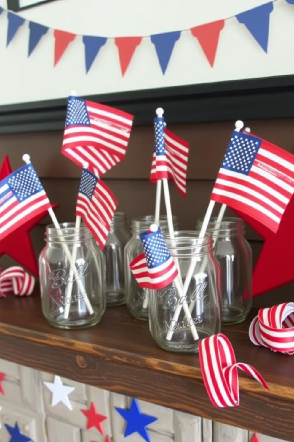 A festive mantel decorated for Independence Day features several mason jars filled with miniature American flags. The jars are arranged on a rustic wooden surface, complemented by red, white, and blue accents such as stars and striped ribbons.