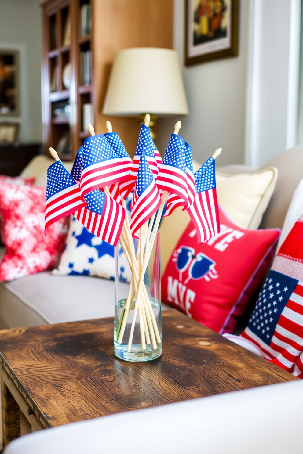 A cheerful display of miniature American flags arranged in a clear glass vase sits on a rustic wooden table. The vibrant colors of the flags add a festive touch to the small space, perfectly capturing the spirit of Independence Day celebrations. Creative small space decorating ideas are incorporated with the use of bright cushions and a patriotic-themed throw blanket on the sofa. The overall arrangement enhances the cozy atmosphere while showcasing a love for the holiday.