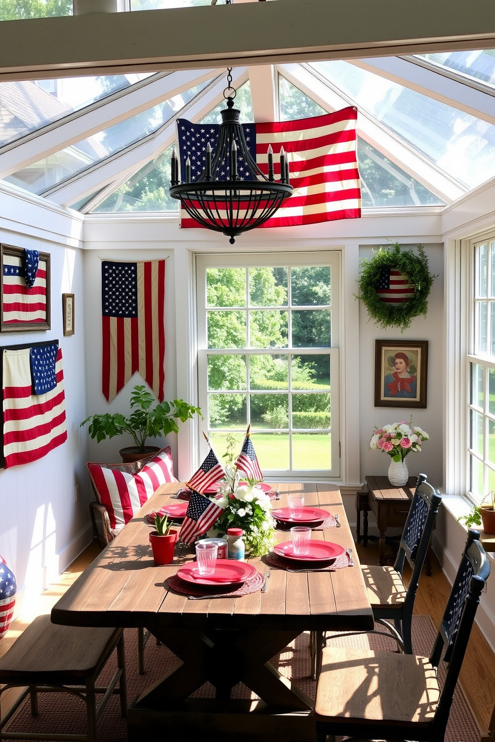 A sunroom filled with natural light showcases vintage American flag decor pieces that celebrate Independence Day. The walls are adorned with framed flags in various sizes, while a rustic wooden table is set with red, white, and blue accents, creating a festive atmosphere.