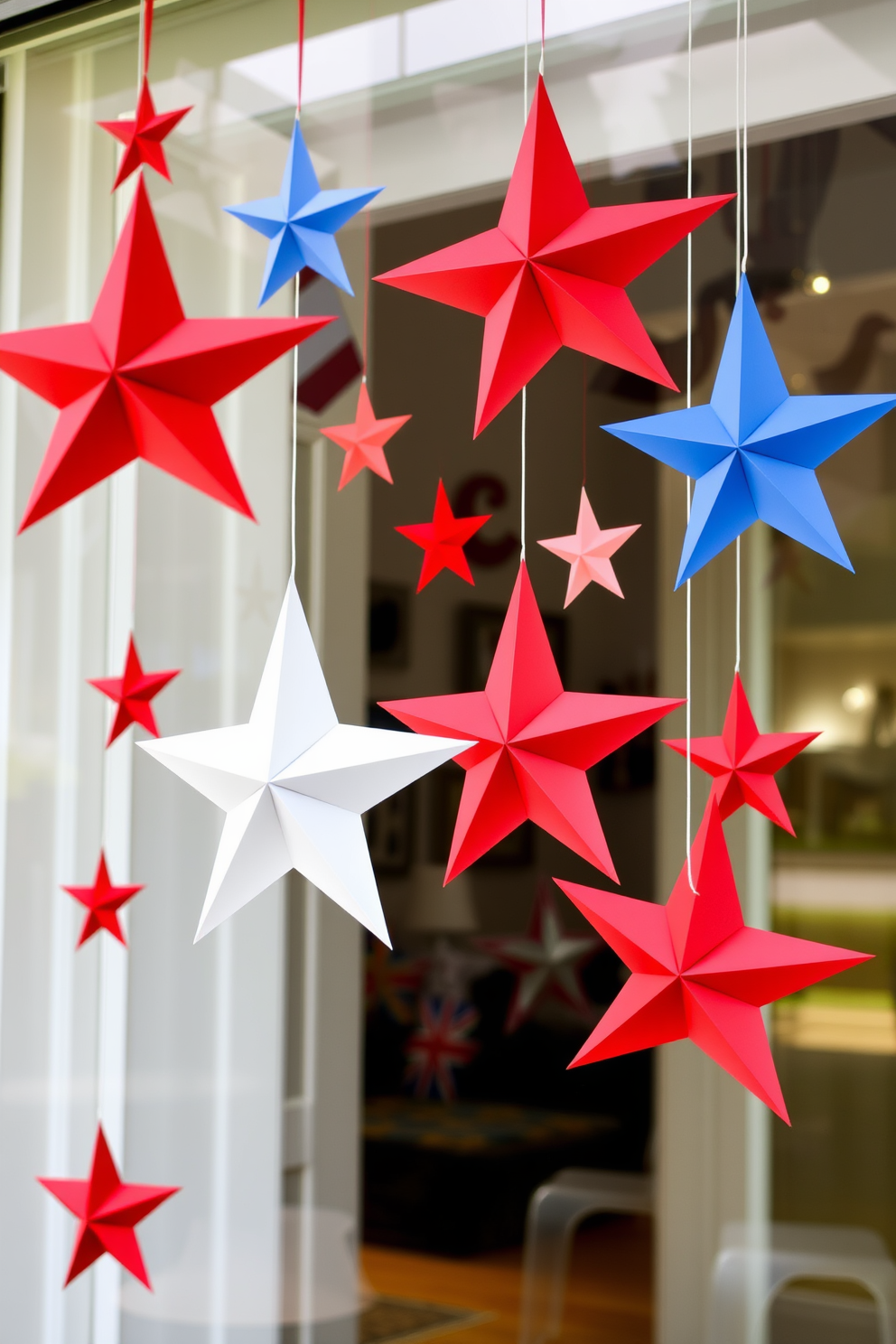 Create a festive window display featuring hanging paper stars in various sizes to celebrate Independence Day. The stars should be crafted in red, white, and blue, creating a vibrant and patriotic atmosphere.