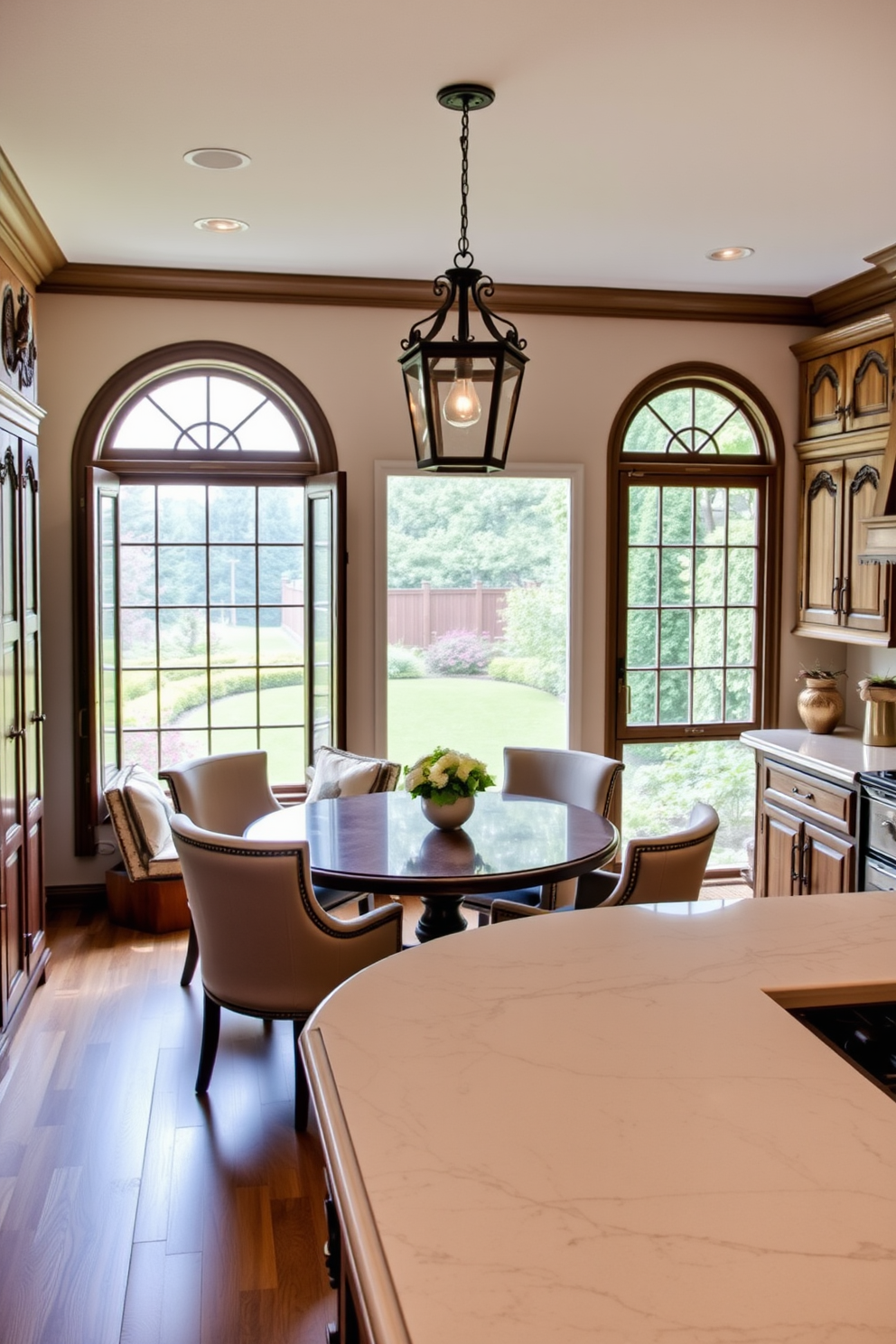 Charming breakfast nook with a cozy round table surrounded by upholstered chairs. The large window offers a beautiful view of the garden, allowing natural light to fill the space. Italian kitchen design featuring rustic wooden cabinets with intricate carvings. A spacious island with a marble countertop serves as the centerpiece, complemented by vintage pendant lights hanging above.