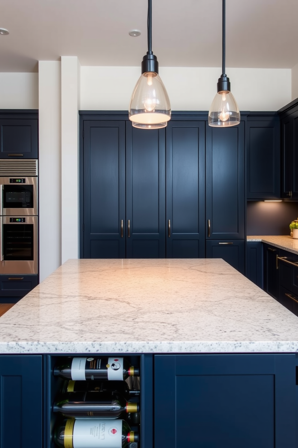 A modern kitchen space featuring a sleek island with a polished granite countertop. The island is complemented by a stylish wine rack integrated into one side, showcasing an array of fine wines. The cabinetry is a rich navy blue, providing a striking contrast to the light-colored walls. Pendant lights hang above the island, illuminating the space and creating a warm, inviting atmosphere.