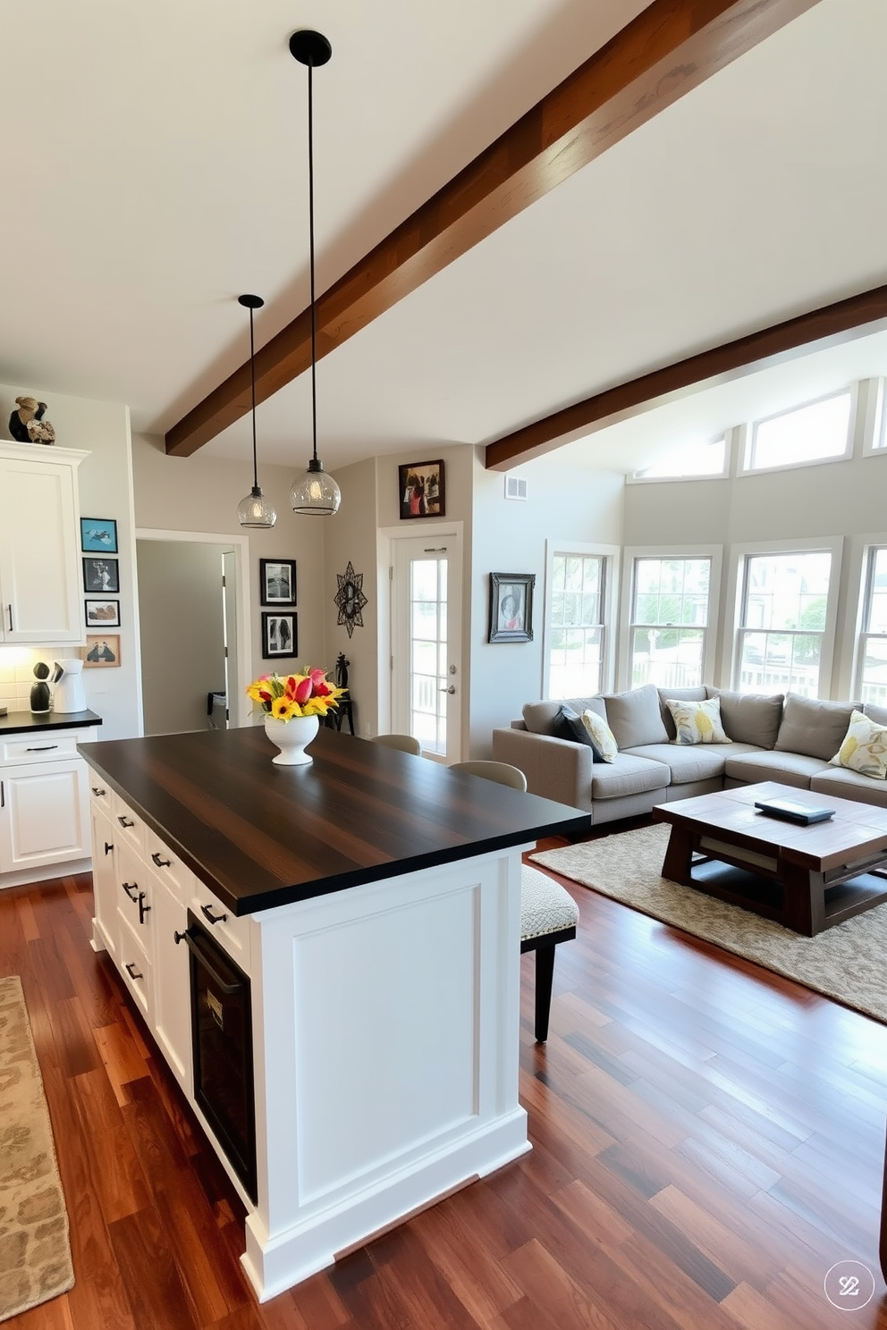 A warm and inviting kitchen family room combo features an open layout with a large kitchen island that serves as a central gathering space. The cabinetry is a soft white, complemented by a dark wood countertop, while personal artwork adorns the walls, adding a unique touch to the space. In the family room area, a plush sectional sofa in a neutral tone invites relaxation, paired with a rustic coffee table made from reclaimed wood. Large windows allow natural light to flood the room, highlighting the vibrant colors of the personal artwork displayed throughout the area.