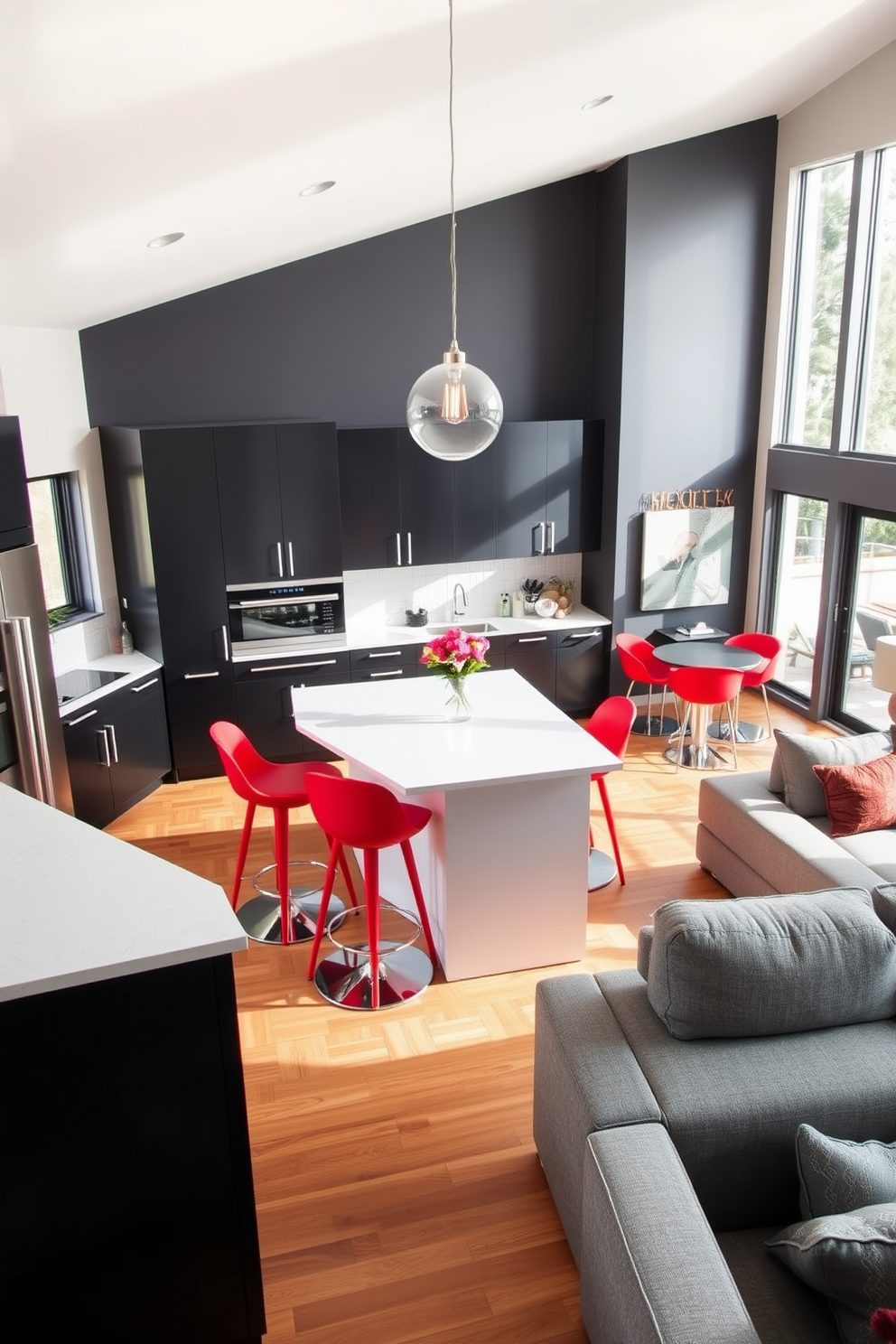 A modern kitchen and family room combo featuring sleek black cabinets paired with a bright white island. The open space is accentuated by vibrant red bar stools and a large sectional sofa in a soft gray fabric. Natural light floods the area through large windows, highlighting the warm wood tones of the flooring. A contemporary pendant light hangs above the island, adding a touch of elegance to the inviting atmosphere.